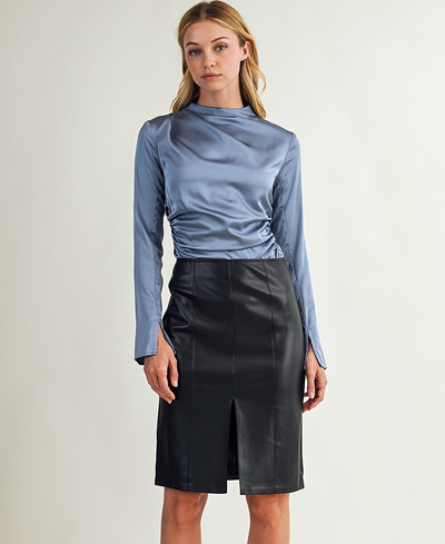 Woman wearing a blue satin top and black leather skirt on a white background