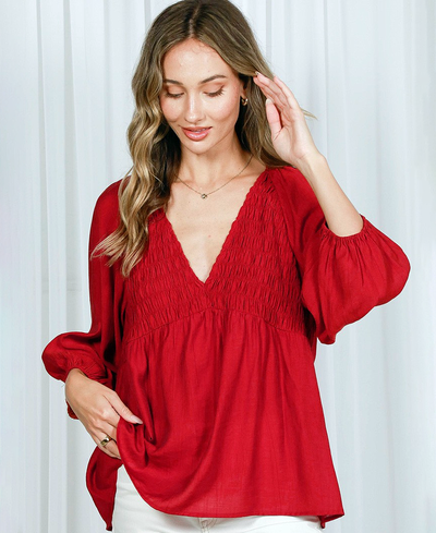 Woman wearing a red blouse against a white background