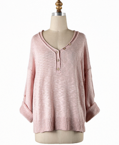Pink sweater on a mannequin against a white background