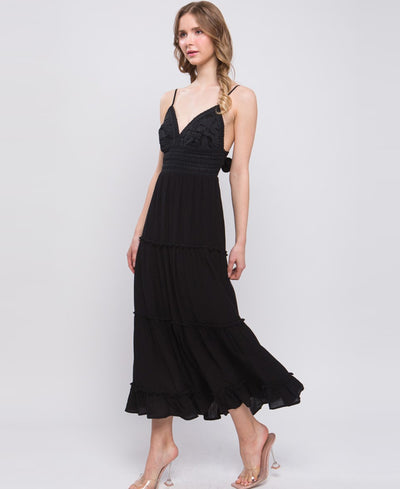Black spaghetti strap dress. Front is detailed with lace and the dress goes down to the ankle region.