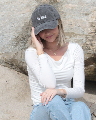 Grey baseball cap that says "Be kind" in white lettering. 